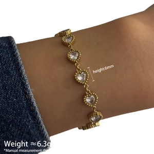 Bracelet doré pour femme avec zircons en forme de cœur de 6mm porté sur le poignet