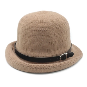 Detail of khaki knitted bowler hat featuring a black leather band and metal buckle