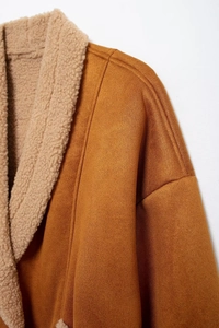 Detailaufnahme der braunen Wildlederoptik und des weichen Lammwollkragens dieser Jacke