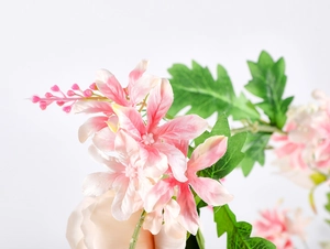 Macro detail of artificial rose vine with gradient pink petals and green leaves