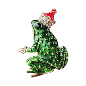 Sparkling crystal frog brooch with green enamel finish and gold crown in white background