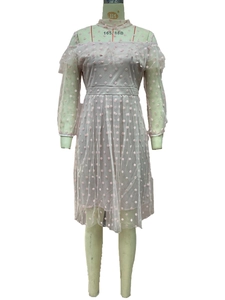 Detail of pink polka dot mesh gown featuring off-shoulder ruffles and long sheer sleeves