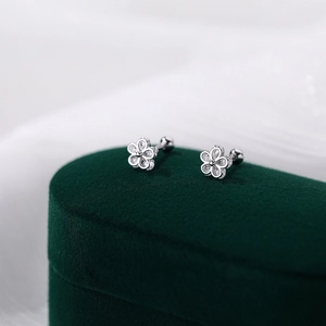 S925 sterling silver flower stud earrings with sparkling cubic zirconia on green velvet