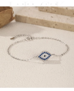 Macro detail of S925 sterling silver evil eye bracelet with blue gems and lucky charm