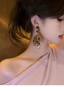 Detailed view of acetate leaf pendant earrings with vintage amber tortoise shell texture