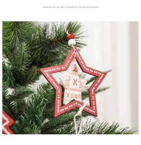 Close-up of red and white wooden star ornament with reindeer motif on Christmas tree