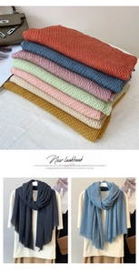 Detail of pleated cotton linen scarves in various colors including orange and blue