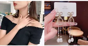 Detail of S925 silver long pearl tassel earrings with crystal bow on elegant model