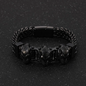 Detailed view of black woven titanium steel bracelet with three carved wolf heads
