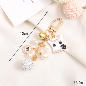 Elegant gold keychain with pearls and black enamel flower pendant, 10cm long design