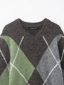 Détail du pull en tricot à col en V avec motif à losanges et texture de laine duveteuse