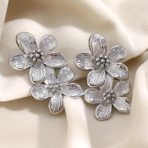 Macro detail of vintage double flower earrings in silver finish with petal textures