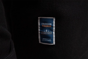 Detailed macro view of black waffle texture fabric with a fashion trends woven label
