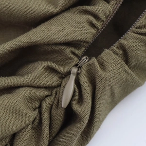 Dettaglio dell'abito midi in lino verde militare con cerniera invisibile e trama del tessuto