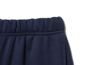Detailed view of dark blue athletic pants featuring an elastic waistband and dual stitching