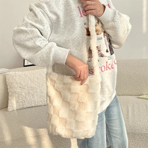 Furry checkerboard shoulder bag in cream and khaki shown on a model for daily style