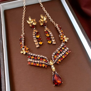 Detailed view of vintage gold flower jewelry set with ruby red and amber crystals