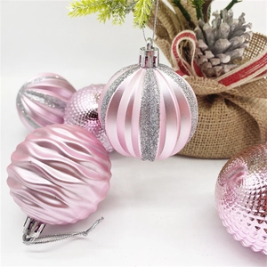 Detailed view of pink Christmas ornaments with glitter stripes and wavy patterns