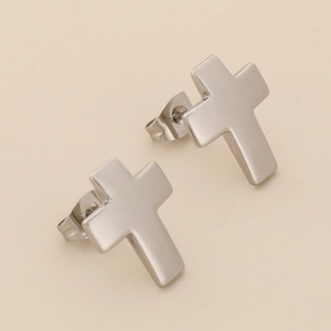 Close-up of minimalist silver stainless steel cross stud earrings with smooth finish
