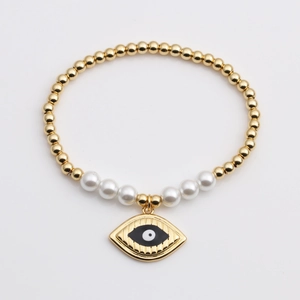 Bracelet à perles dorées avec perles et pendentif cœur œil protecteur sur fond blanc