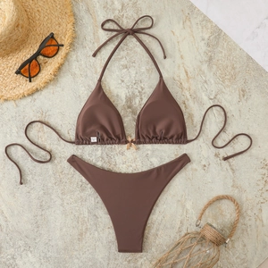 Flat lay of brown bikini with starfish gold detail and seaside vacation accessories