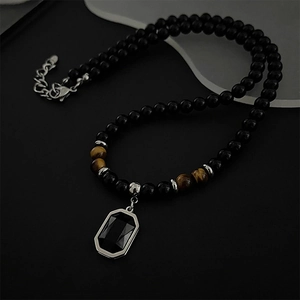 Collana minimalista con perline nere, occhio di tigre e ciondolo geometrico in argento