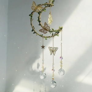 Detail of moon suncatcher with yellow crystal pendant, butterfly decor and rainbow prism