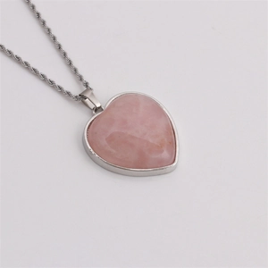 Detail of pink heart crystal pendant with silver twisted chain and metal edging