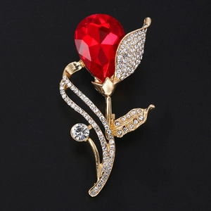 Detailed view of a red rose brooch with sparkling crystals and gold-plated metal base