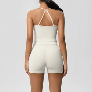 Detail view of cream backless yoga set featuring V-shaped cross straps and high waist