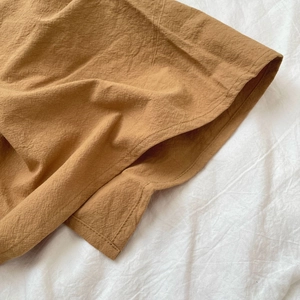 Detailed close-up of mustard yellow cotton apron featuring durable stitching and natural texture