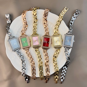 Square quartz wristwatches with rhinestone bezels in various colors on a ceramic tray