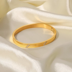 Dettaglio del bracciale placcato oro 18K con motivi diagonali e zirconi su seta bianca