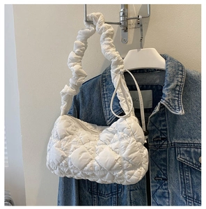 Detail einer weißen gesteppten Nylontasche mit gerafftem Griff und Reißverschluss