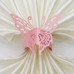 Macro detail of laser-cut pink butterfly napkin ring with a pearlescent paper finish