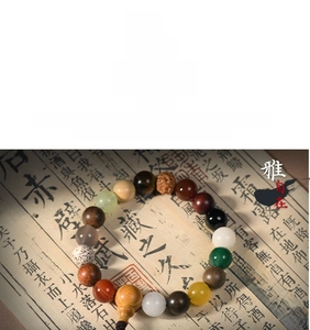 Detailed close-up of mixed natural wood and agate prayer beads on a calligraphy book