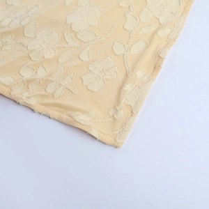 Dettaglio macro del tessuto jacquard floreale goffrato 3D giallo tenue con cuciture