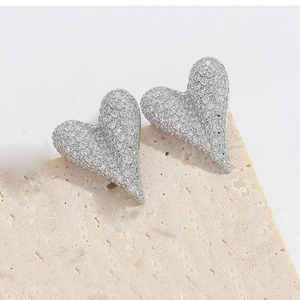 Macro detail of silver heart earrings with micro-paved white cubic zirconia crystals