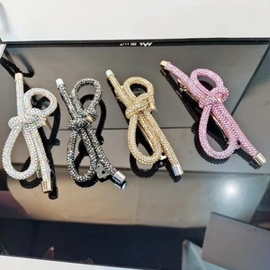 Dettaglio di quattro fermagli per capelli a fiocco con strass argento nero oro e rosa