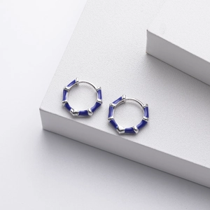 Macro shot of silver bamboo-joint hoop earrings with elegant blue enamel detailing