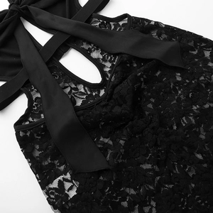 Detail of sheer floral lace fabric and satin ribbon ties on a black halter jumpsuit