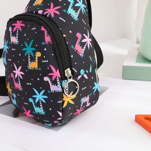 Detailed close-up of a black kids chest bag with colorful dinosaur and palm tree patterns