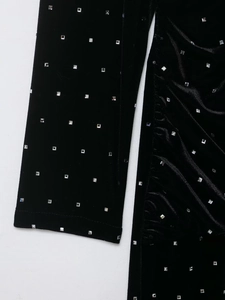 Detalle de primer plano de vestido de terciopelo negro con brillantes cuentas de strass