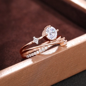 Gedetailleerde macro-opname van een roségouden ring met kruislingse ster en zirkoon