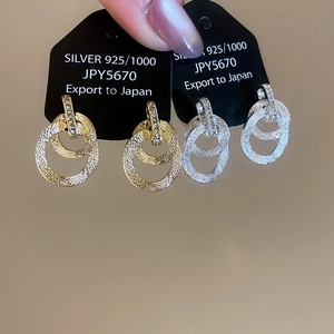 Dettaglio di orecchini in argento 925 placcati oro 18k con zirconi e texture opaca