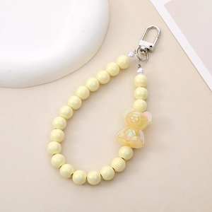 Close-up of a handmade yellow beaded keychain with a cute transparent bear pendant