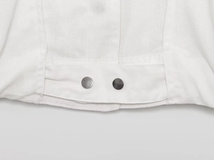 Detailed macro view showing the white linen texture and silver metal buttons of the jacket