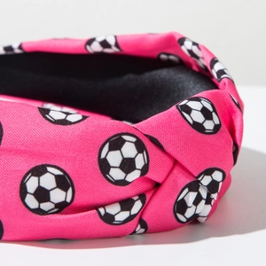 Detail eines rosaroten Stirnbands mit Fußballmuster und stilvollem Knotendesign