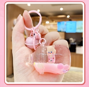 Détail du porte-clés bouteille de lait rose avec sable mouvant liquide et figurine
