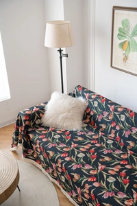 Close-up of tulip jacquard fabric texture and fringe details on a retro sofa throw